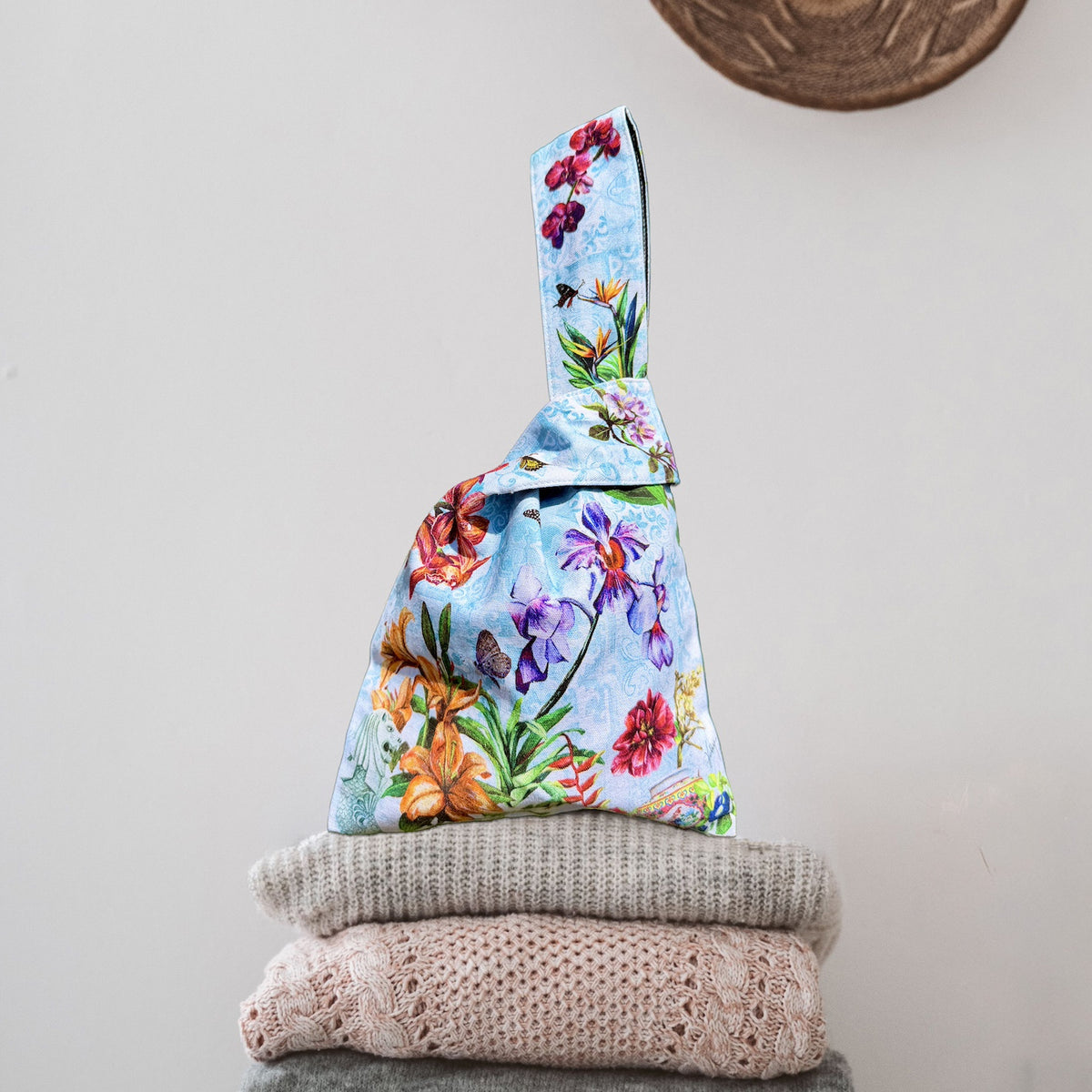 Close-up of Nyonya porcelain teapot and native Singapore flora art on fabric knot bag