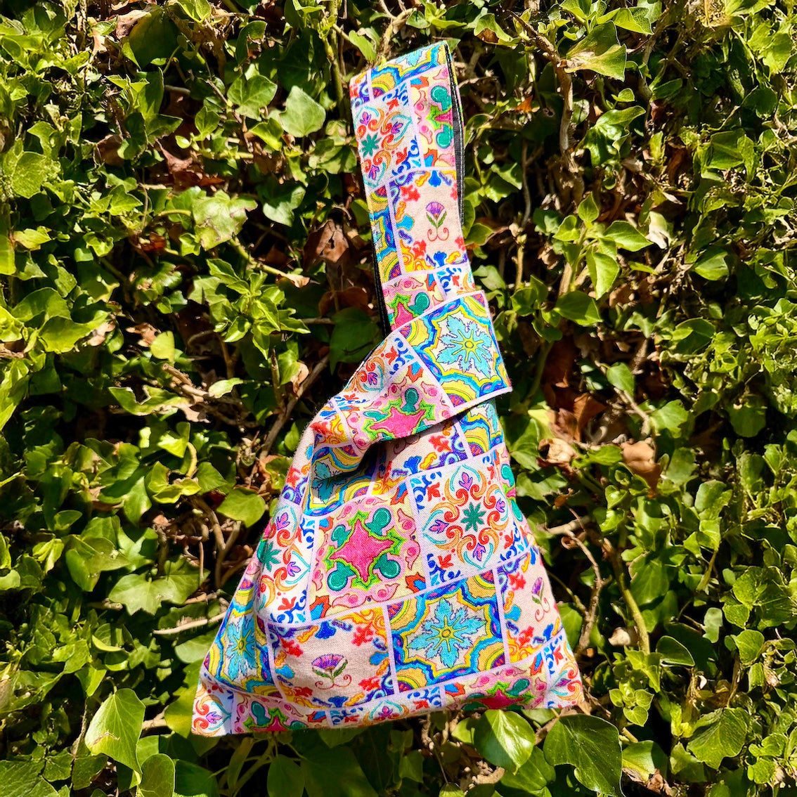 Compact Japanese knot bag holding smartphone, cardholder, and keys for daily use