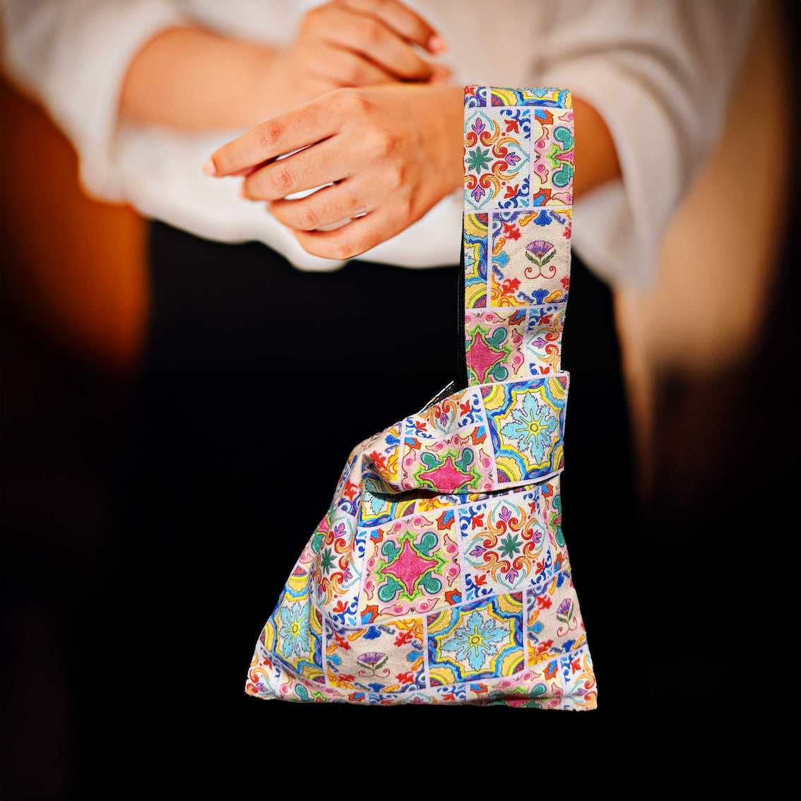 Woman carrying hands-free Japanese knot bag wristlet made from Kelly Ser tile print canvas featuring hand painted art design